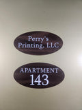 Oval wood grain apartment number and business door signs with white text on a gold background
