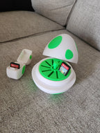 3D printed Yoshi egg SD card holder and small storage box on a gray couch