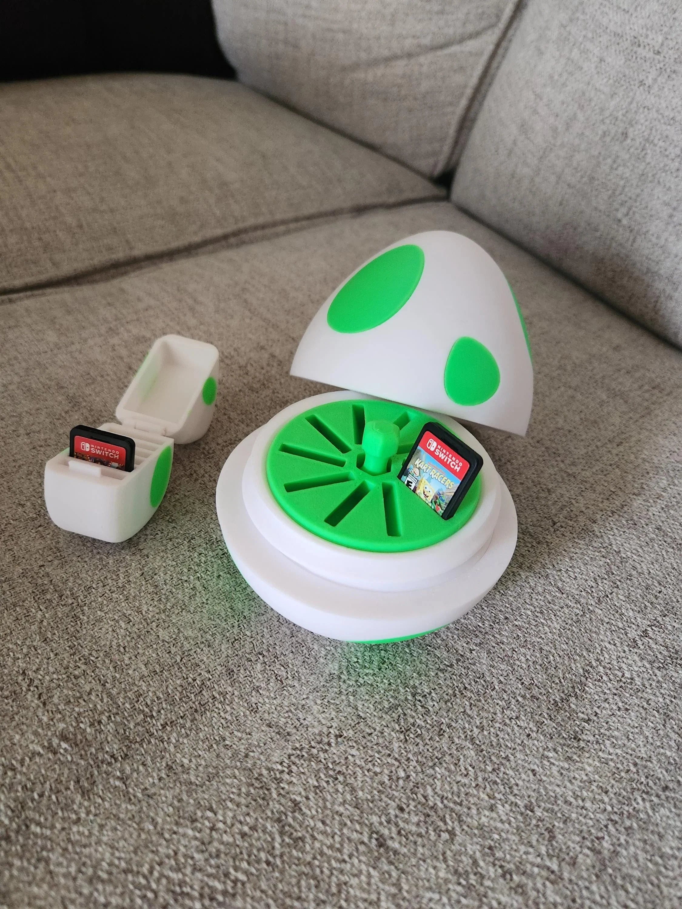 3D printed Yoshi egg SD card holder and small storage box on a gray couch
