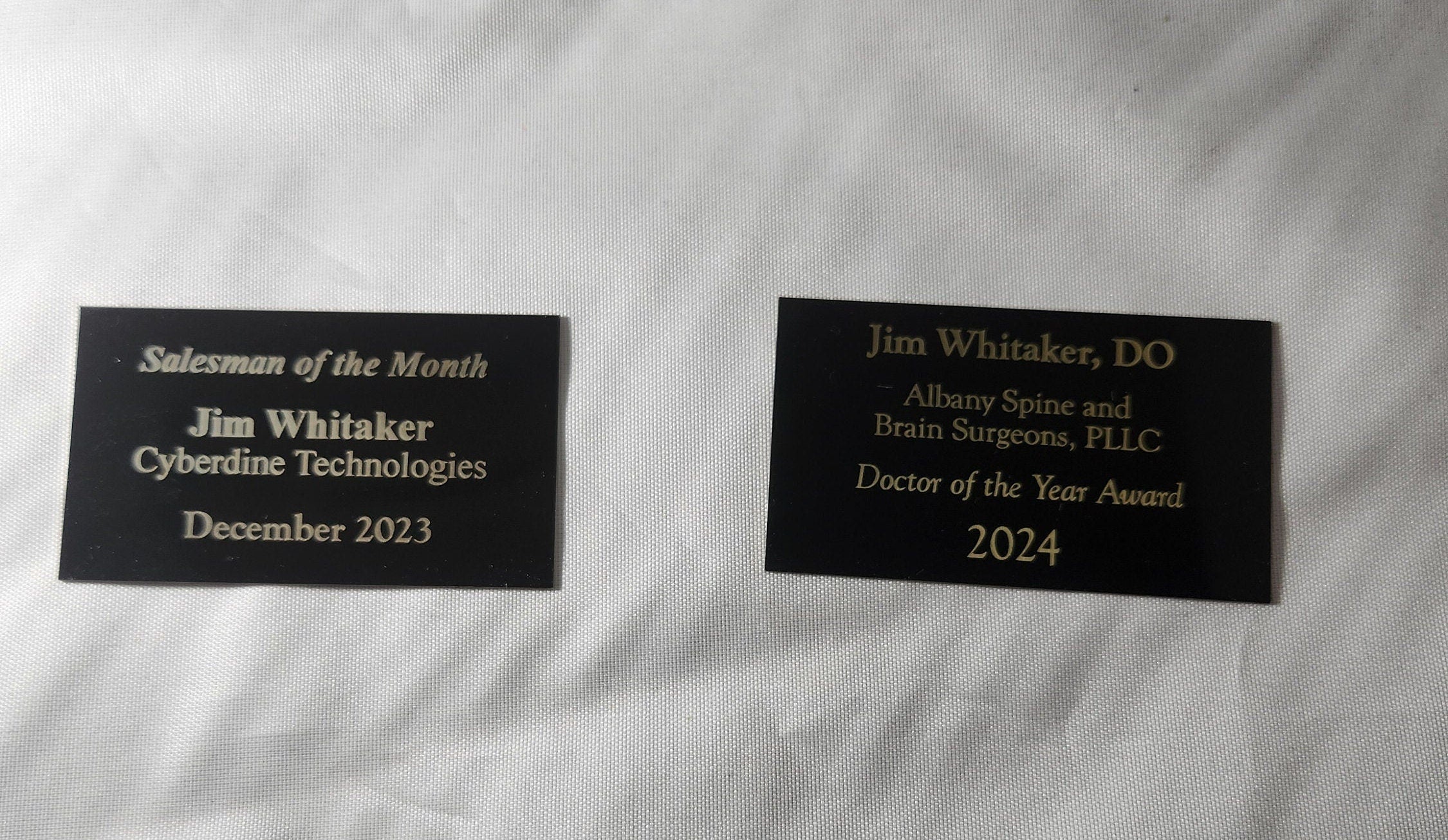 Custom laser engraved award plaques with gold text on black, for sales and professional achievements.