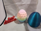 3D printed dragon egg with pastel scales, metallic blue egg, and red Perry's Printing sign