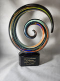 Colorful glass swirl award with engraved plaque for salesman of the month on white background