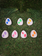 Colorful spotted egg-shaped 3D printed tokens on grass, assorted pairs for matching game