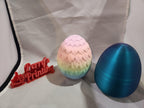 3D printed rainbow dragon egg, metallic blue egg, and red Perry's Printing sign on display