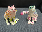 3D printed colorful snow leopard figurines with detached segmented tails on a gray fabric surface