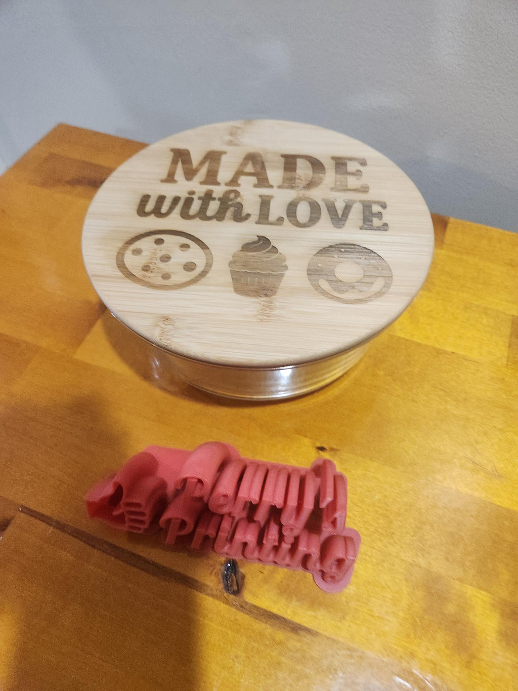 Laser engraved wooden lid with Made with Love and dessert icons, plus red 3D printed text object