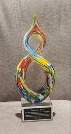 Handcrafted helix-shaped multicolor art glass award with a custom engraved silver plaque for Susanne Rice on a clear crystal base