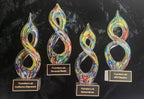 Art glass sculpture award featuring a vibrant swirl design and a custom plaque honoring leadership.