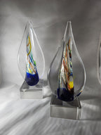 Colorful glass art awards with abstract swirls on clear bases, ideal for custom engraving