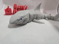 3D printed articulated shark figurine with cartoon smile and blue eyes on white background