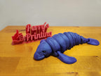 3D printed purple manatee figurine and red sign with thumbs up on wooden table