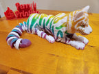 Colorful 3D printed articulated tiger figurine with rainbow stripes on a wooden surface
