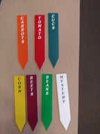 Colorful engraved garden plant markers labeled carrots, tomato, cucs, corn, beets, beans, mystery