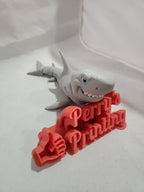 3D printed shark figure with red 'Perry Printing' and thumbs up sign on white background.