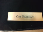 Custom engraved gold desk name plate on a black background