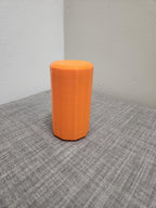 Orange 3D printed octagonal container on a gray fabric surface