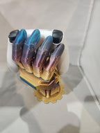 Colorful 3D printed mechanical hand model with gold, blue, and purple metallic finish