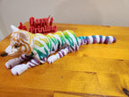 Colorful 3D printed jointed tiger figurine on wood table with Perry's Printing sign