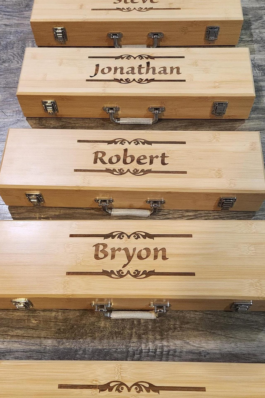Personalized laser engraved wooden cases with custom names on a rustic wood surface.