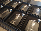 Custom engraved black groomsman flasks with tuxedo design and names in gift boxes