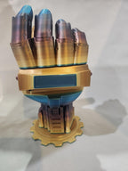 3D printed metallic robotic hand model on gear-shaped base against plain background