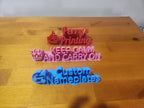 3D printed custom nameplates and signs with colorful text designs on a wooden table