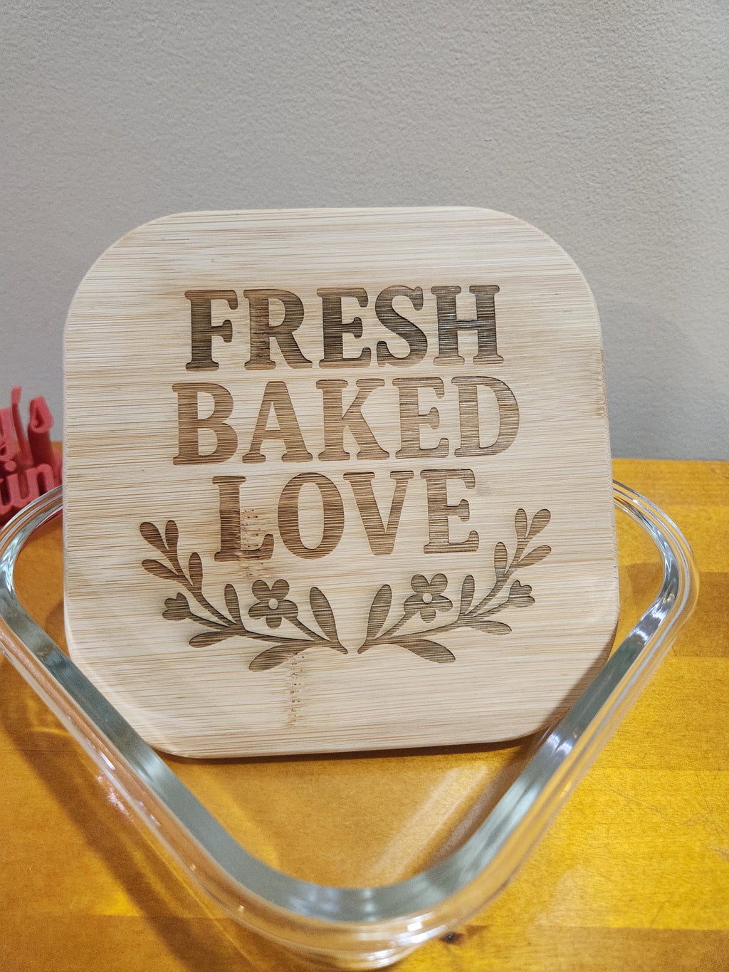 Laser engraved bamboo sign with 'Fresh Baked Love' and floral design on wood table
