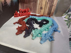 Colorful 3D printed dragon figurines on display with custom signage, fantasy decor
