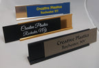 Custom engraved name plates with metal holders, ideal for office desk signage.