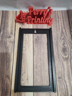 3D printed black sign holder frame on wood surface, with red 'Perry's Printing' logo