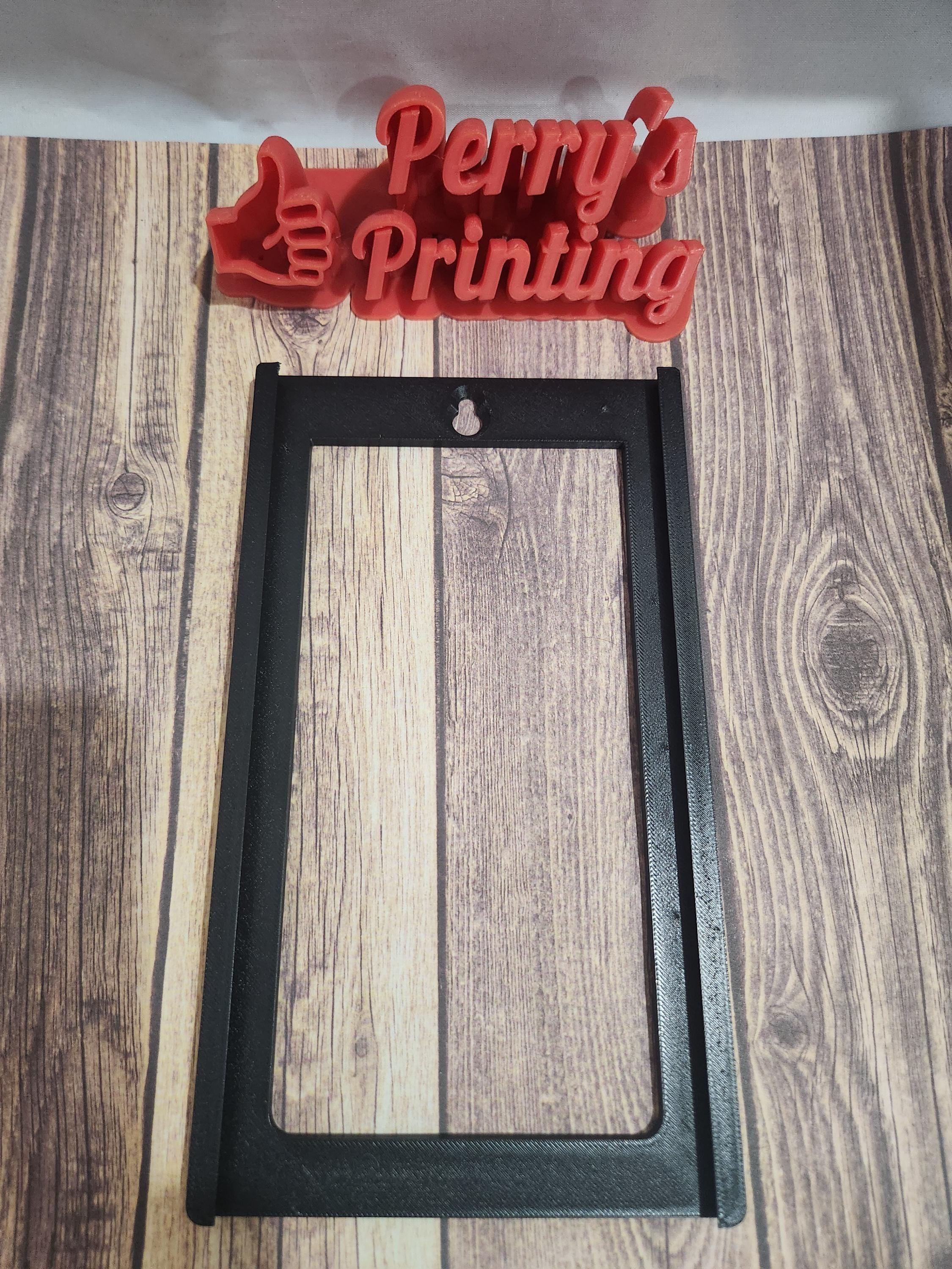3D printed black sign holder frame on wood surface, with red 'Perry's Printing' logo