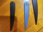 Three 3D printed propeller blades, black and blue, displayed on a wooden surface.