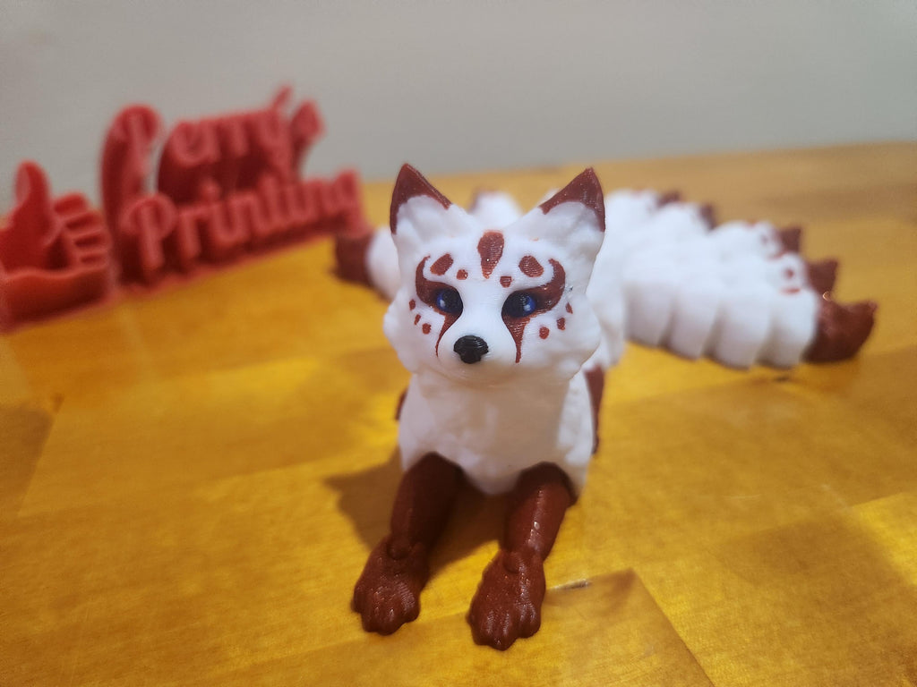 3D printed white and brown fox figurine with painted details on a wooden surface