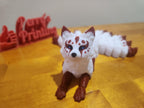 3D printed white and brown fox figurine with painted details on a wooden surface
