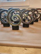 Colorful swirl glass awards with black bases displayed on a table, custom recognition trophies