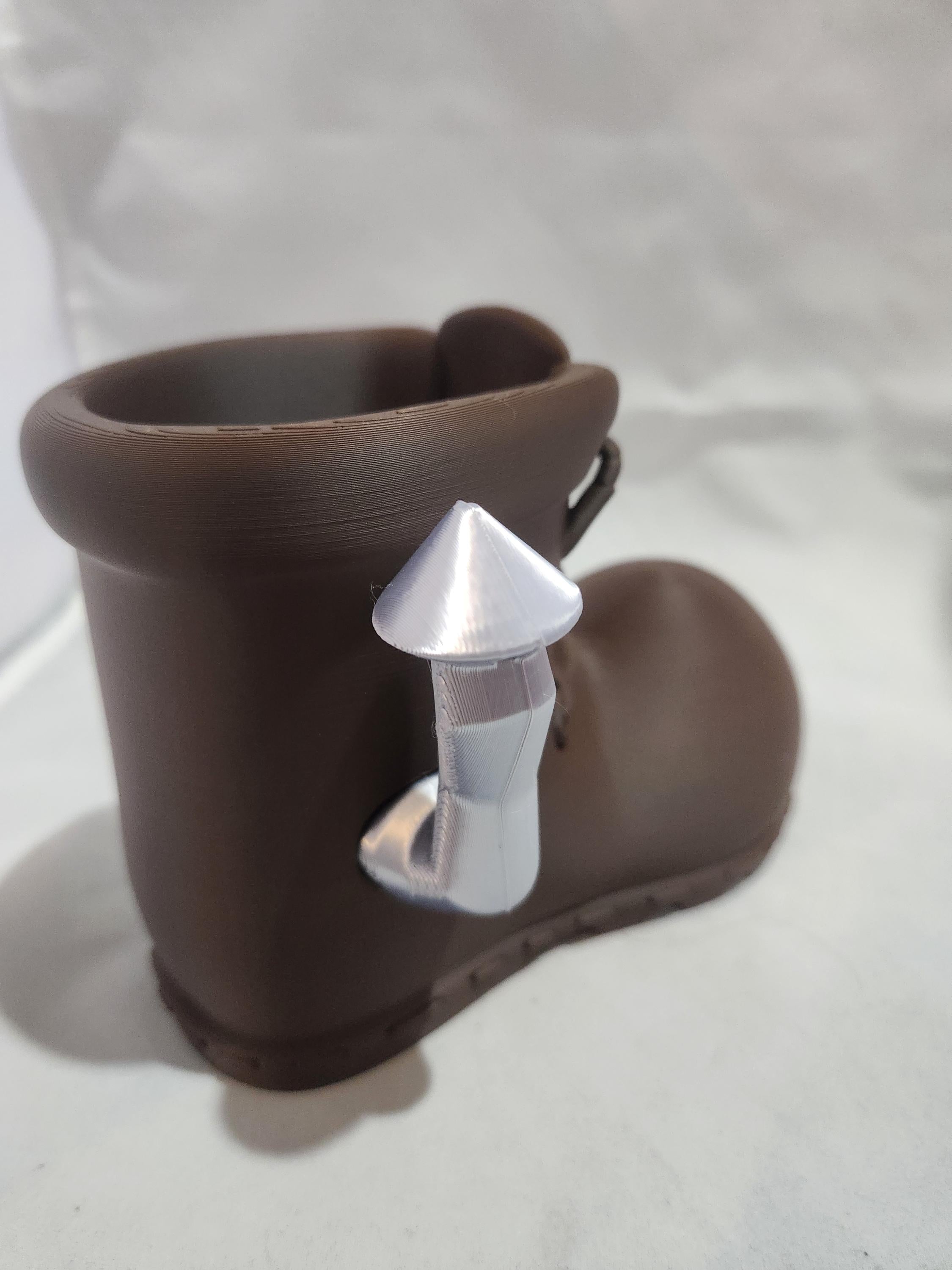 3D printed brown boot-shaped planter with attached silver spout on white background
