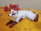 3D printed nine-tailed fox figurine with red and white detailing on a wooden surface