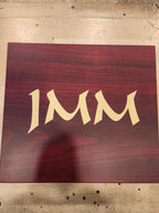 Custom laser engraved wooden plaque with gold text on a reddish wood background