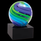 Colorful glass award with blue, green, and purple swirls on a black base, isolated on black