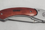 Personalized folding pocket knife with engraved wooden handle on white background