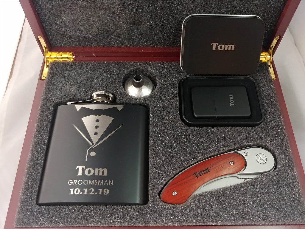 Personalized groomsman gift set with engraved flask, lighter, pocket knife, and metal tin in a wood box.