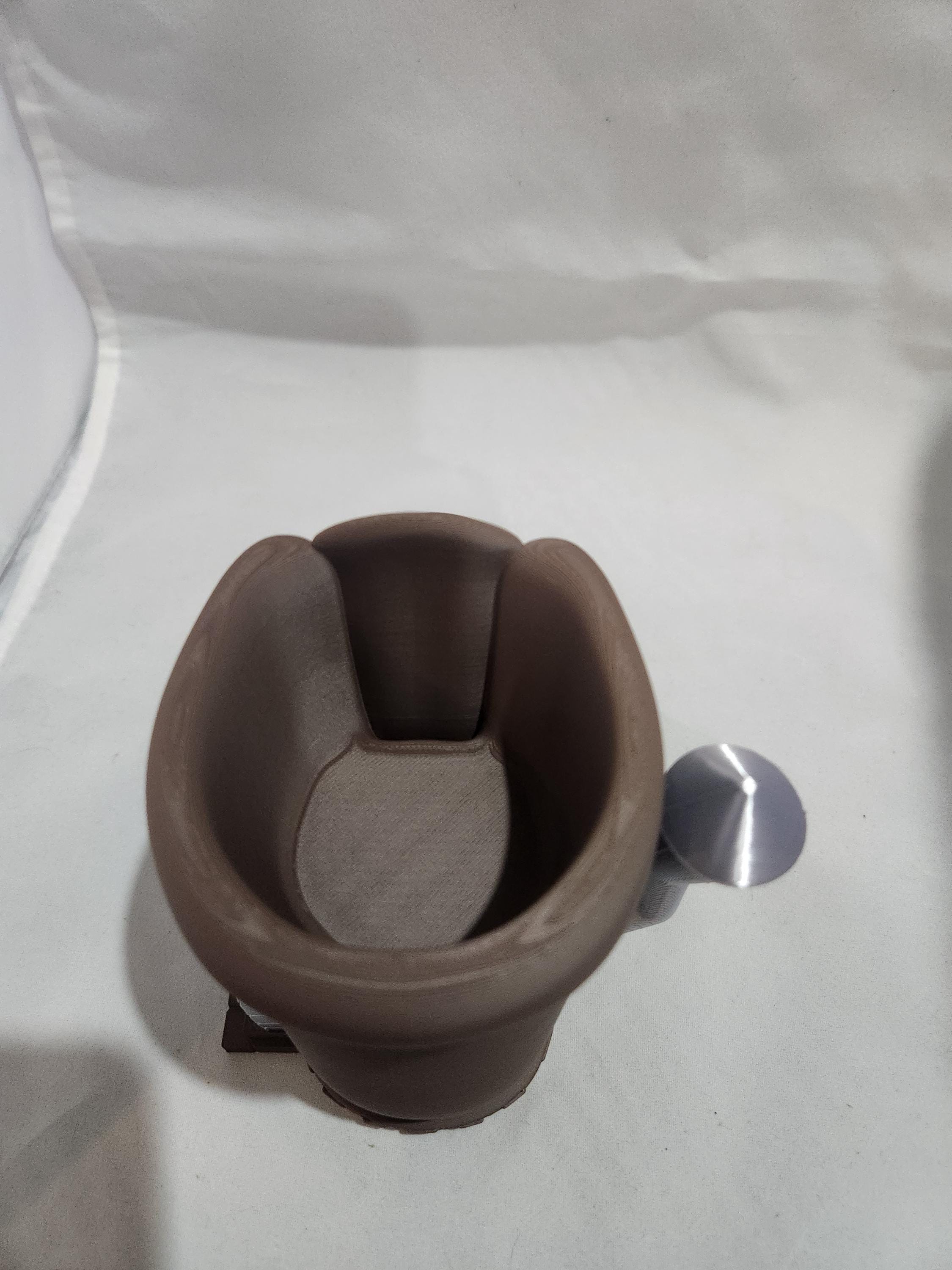 3D printed brown knock box with metal bar for espresso puck disposal on white background
