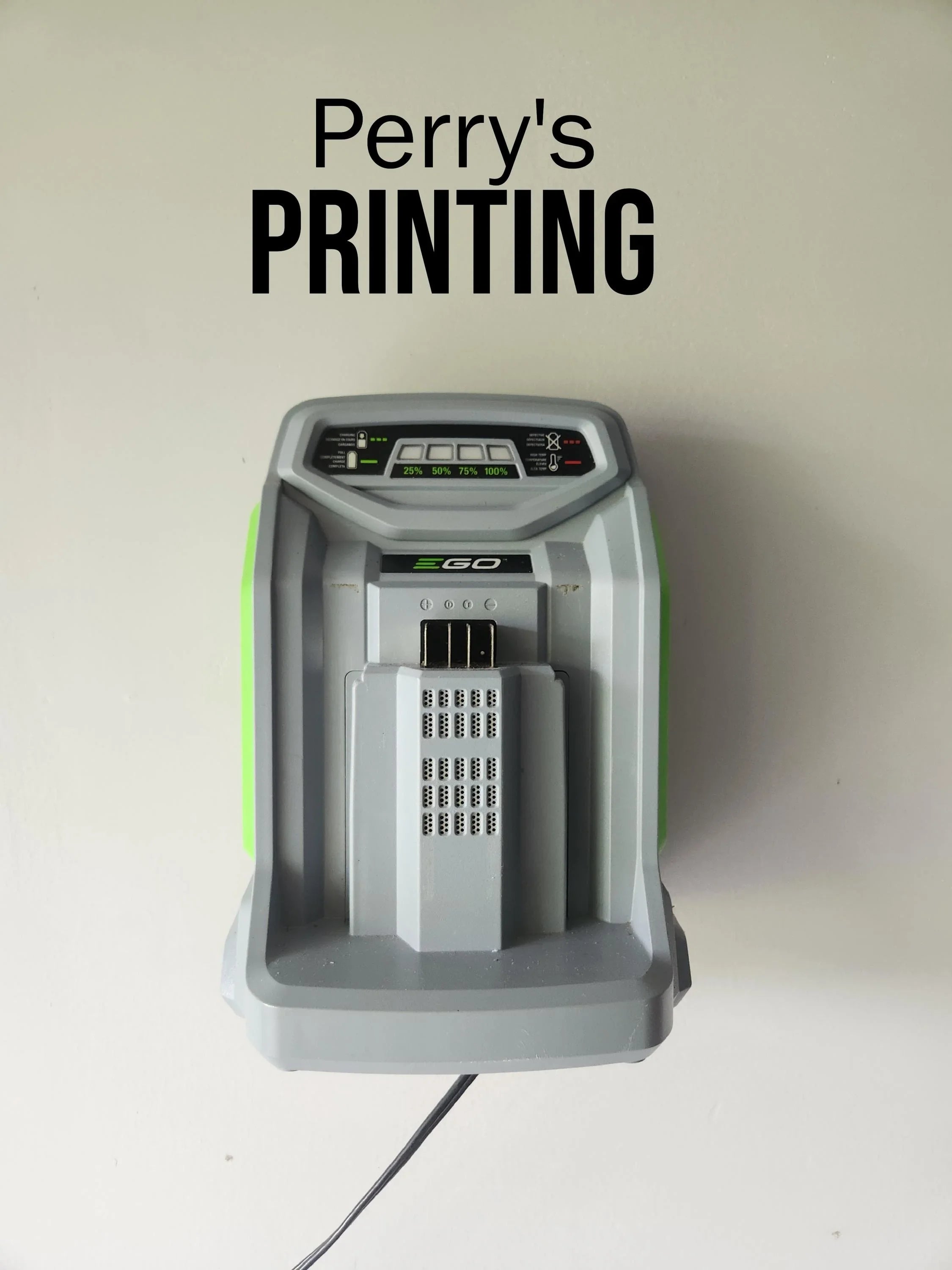 Wall-mounted battery charger below 'Perry's PRINTING' text on white background.