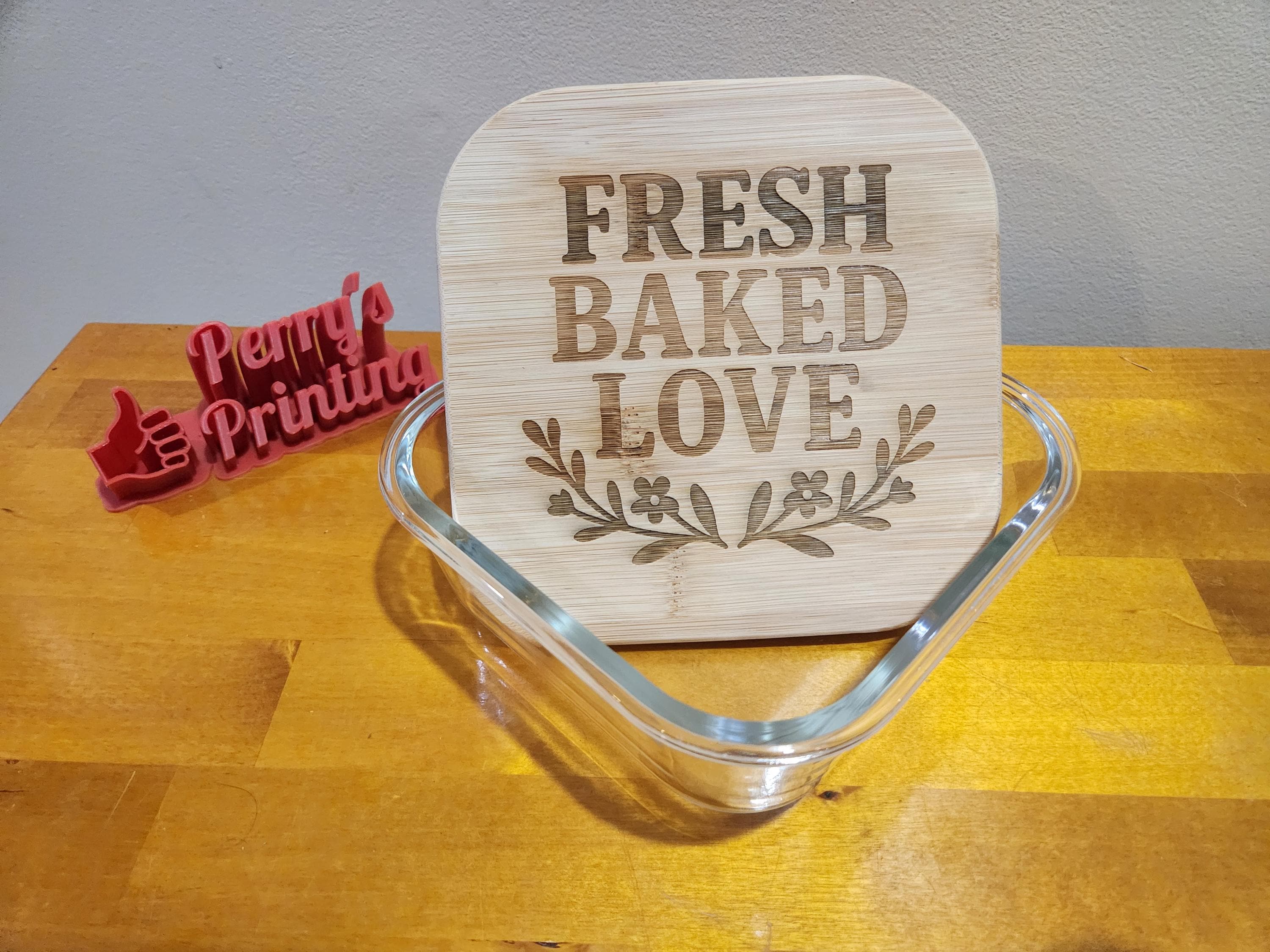 Laser engraved bamboo cutting board with 'Fresh Baked Love' design in glass baking dish