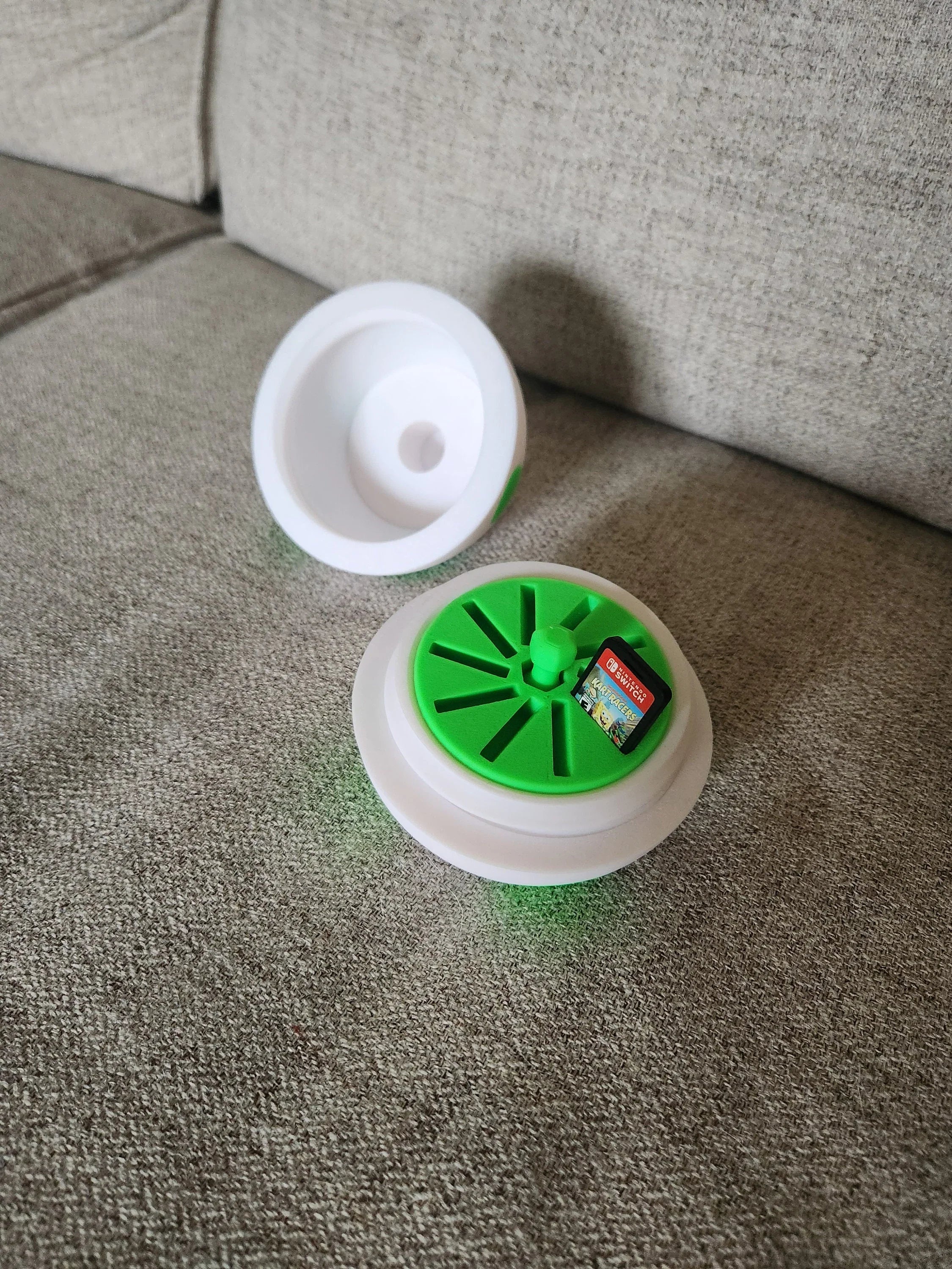 3D printed green and white storage container for Nintendo Switch game cards on a beige couch