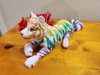 Multicolor 3D printed tiger figure with rainbow stripes on a wooden surface