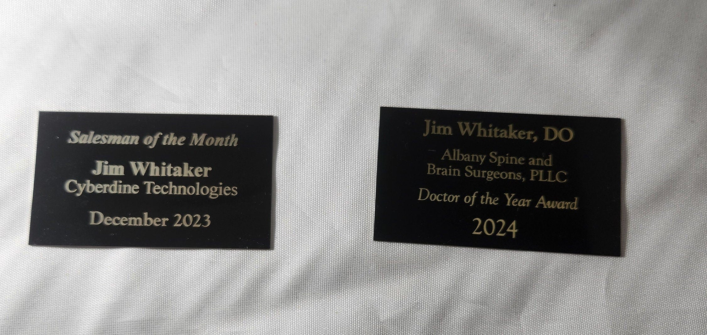 Custom engraved award plaques with gold text recognizing achievements, ideal for events and businesses