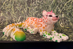 Colorful 3D printed articulated leopard figurine with orange, green, and red spots on grass