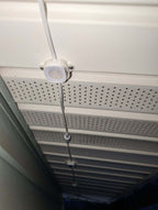 Close-up of LED soffit lights installed under perforated eaves with visible wiring