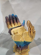 3D printed mechanical hand in metallic gold and blue colors, posed upright on display.